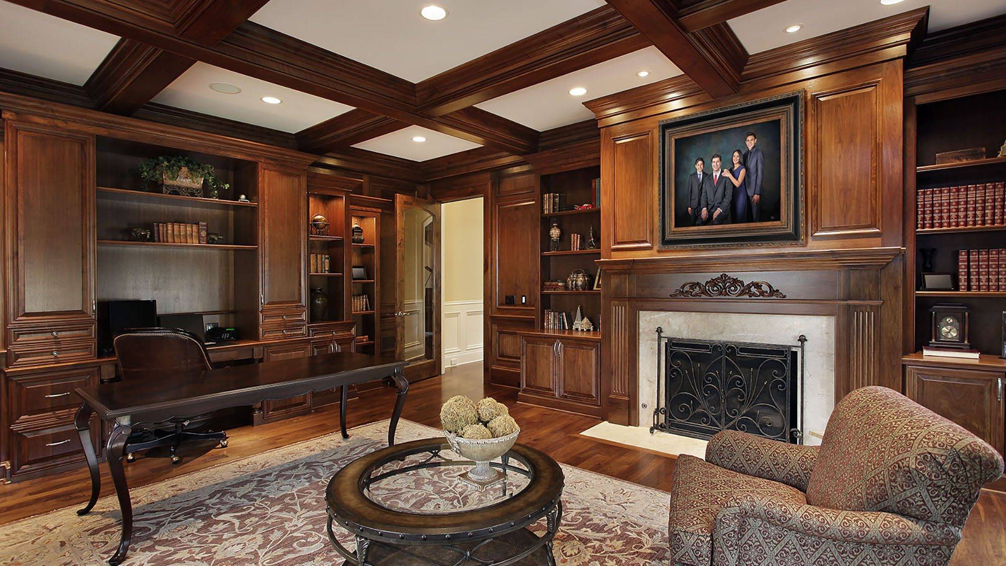 KGS Studios family legacy portrait hanging above the fireplace in a classic, wood-paneled library and study.