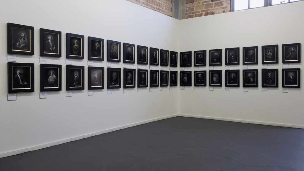 An exhibit wall at the Brick Event Center featuring the KGS Studios "Notable People of San Antonio" collection.