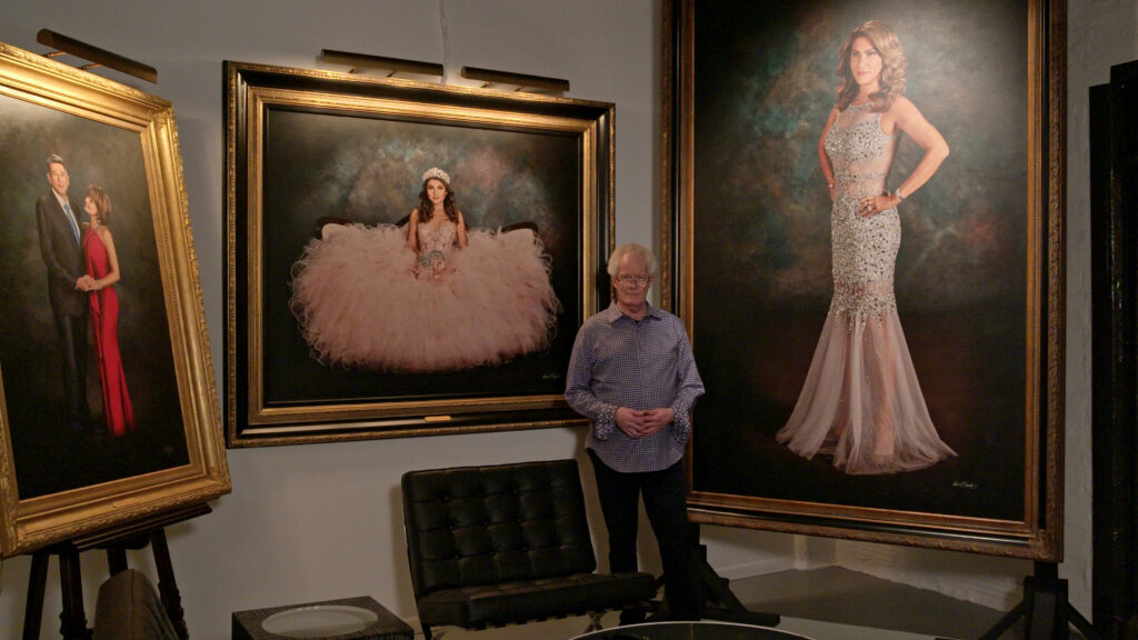 Kevin G. Saunders standing in KGS Studios at 107 Blue Star between Madame Tex portrait and Heather bridal portrait – self-taught mastery from first principles